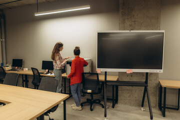 Two Colleagues Discussing Work in a Modern Office Environment