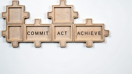 Inspiring wooden puzzle pieces featuring commit act achieve words for motivation and teamwork