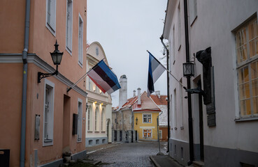Narrow cobblestone street with Estonian flags in Tallinn old town