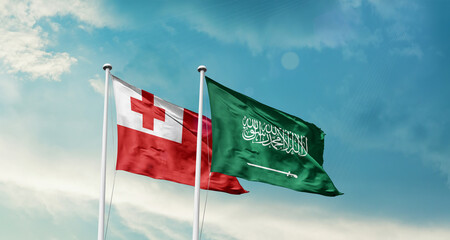 Tonga and Saudi Arabia friendship flags are waving in the sky. Two country flag for agreement or...