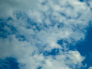 Fluffy white clouds float in a bright blue sky.