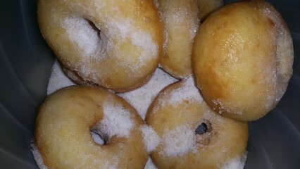 Close up shot of a pile of delicious and indulgent sweet sugar donuts. Donut, Doughnut or Donat, a popular pastry made of flour and potato with sugar icing on top. Delicious snacks for kids and adults