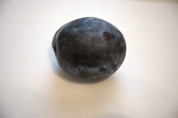 Ripe purple plum isolated on a white background. Close-up with generous copy space.