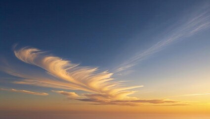 Stunning wispy clouds catch golden sunset light against a deep blue sky