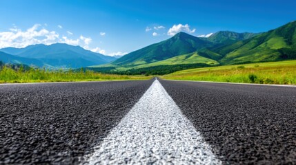 Fototapeta premium Scenic Highway Leading to Majestic Mountains Under a Clear Blue Sky, Representing Travel and Adventure