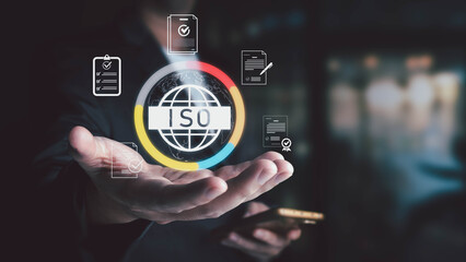 A businessman presents a virtual ISO icon, symbolizing international standards for quality management, assurance, and business process certification.