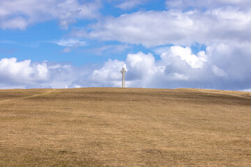 Tennyson Memorial on Tennyson down on the Isle of Wight, with blue sky and fluffy clouds overhead