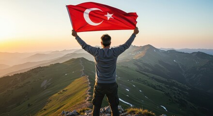 Obraz premium Majestic Turkish Ascent: A figure triumphantly raises the Turkish flag high atop a mountain peak, symbolizing national pride against a backdrop of the vibrant sunrise. 