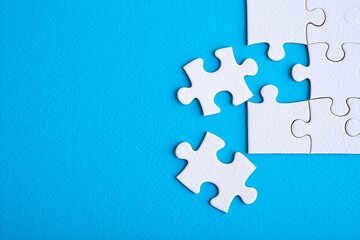 Puzzle pieces on blue background representing problem solving and teamwork concept