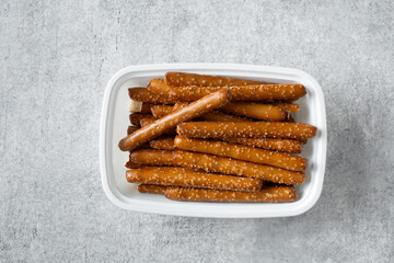 A top down view of a container of gluten-free pretzel rods.