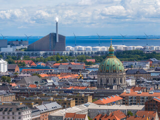 Obraz premium Aerial view of Copenhagen, Denmark, showing Frederik's Church, Amager Bakke waste to energy plant, wind turbines, and the Oresund Strait in the background.