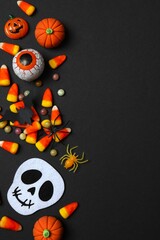 Variuos candies, skull, spider and decorations. Happy Halloween. Top view, space for text