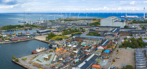 Aerial view of Copenhagen, Denmark, showing offshore wind turbines, a waste to energy plant, industrial buildings, and a vibrant waterfront area.