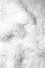 White fabric background. White cuddle teddy bear fabric texture, close up view