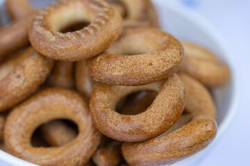 Freshly baked mini bagels on a dark background. Top view. Pretzels in the form of a ring close-up. Small bread circle biscuit. Bowls with different types of bagels.