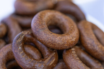 Freshly baked mini bagels on a dark background. Top view. Pretzels in the form of a ring close-up. Small bread circle biscuit. Bowls with different types of bagels.