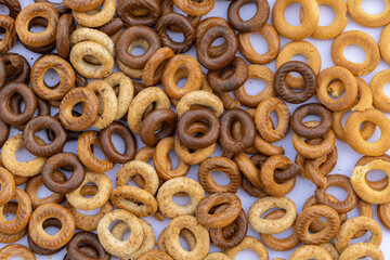 Freshly baked mini bagels on a dark background. Top view. Pretzels in the form of a ring close-up. Small bread circle biscuit. Bowls with different types of bagels.