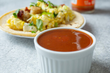 A view of a condiment cup of bottled hot sauce.