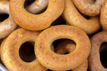 Freshly baked mini bagels on a dark background. Top view. Pretzels in the form of a ring close-up. Small bread circle biscuit. Bowls with different types of bagels.