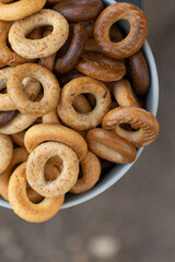 Freshly baked mini bagels on a dark background. Top view. Pretzels in the form of a ring close-up. Small bread circle biscuit. Bowls with different types of bagels.