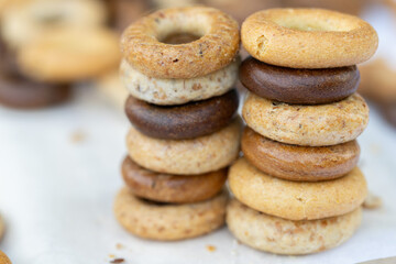 Freshly baked mini bagels on a dark background. Top view. Pretzels in the form of a ring close-up. Small bread circle biscuit. Bowls with different types of bagels.