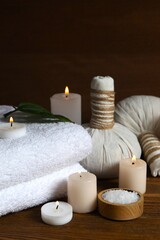Preparation for spa. Different cosmetic products, sea salt and towel on wooden background. Space for text