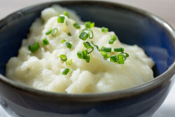 A closeup view of a small bowl of mashed potatoes.
