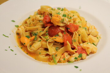 Italian cuisine: tagliatelle with prawns, scallops and tomatoes in Venice, Italy