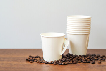 Coffee paper cup on wooden table. Mockup for you designs.