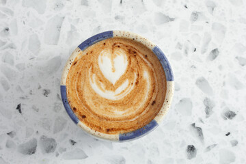 A top down view of a latte coffee drink, featuring latte art.