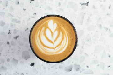 A top down view of a latte coffee drink, featuring latte art.