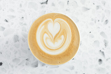 A top down view of a latte coffee drink, featuring latte art.