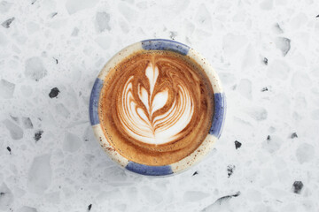 A top down view of a latte coffee drink, featuring latte art.