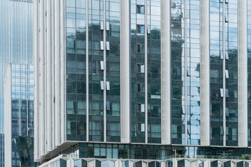 A beautiful background of an glass office building, reflecting clouds in the opened windows