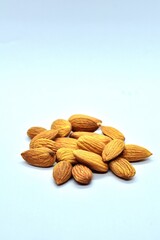 Close-up of raw almonds on a clean white background, highlighting their natural texture, earthy brown tones, and nutritional value as a healthy organic snack.