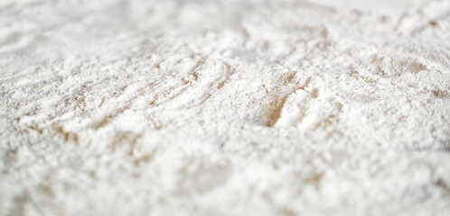Flour close up background. A pile of flour on a white background. Spilled flour. Flour texture. Homemade cooking setup. Cooking recipe setup, homemade baking dough, top view