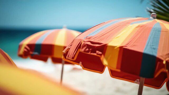 A collection of colorful umbrellas sit atop the sandy beach, ready for use
