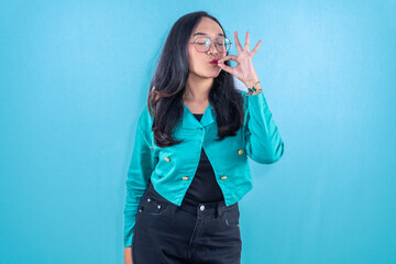 Fototapeta premium Indonesian Asian woman wearing navy dress smiling and giving a sign of pleasure