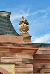Obraz premium Carved Stone Urn and Plant on Roof of Classical Stone Building seen from Below