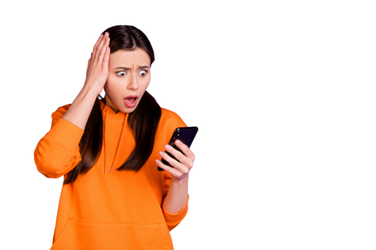 Portrait of astonished youth girl use her cellphone read feednews comment on social network accounts shout wow omg  wear sporty wear isolated over violet purple color background
