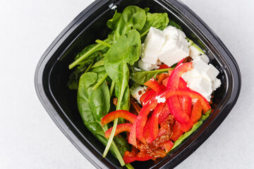 Spinach salad with sun dried tomato feta cheese and red pepper for wellness food or vegetarian lunch menu concept