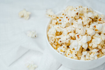 Delicious popcorn served in a white bowl for movie night at home