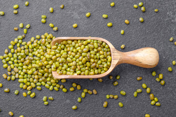 Green Mung Beans In Wooden Scoop On Black Background