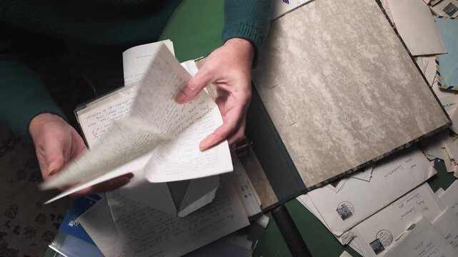 Home archivist organising personal mail letters into A4 plastic sleeve