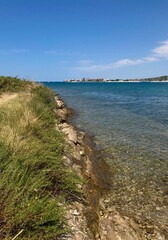 Scenic coastal view with crystal-clear water and rocky shoreline on a sunny day, Adriatic Sea, Croatia.