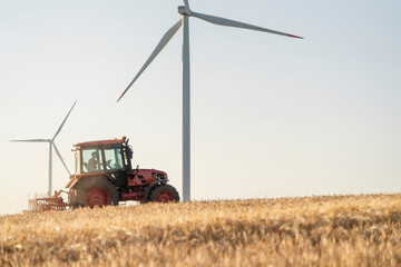 Tractor in field with wind turbine symbolizing sustainable agriculture