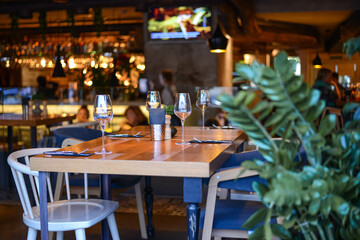 An atmospheric warm photo, a cozy restaurant with dim light and a served table are waiting for the client. book a table in a restaurant for four. High quality photo
