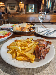 Authentic dining experience in a cozy European tavern with a focus on the main dish of crispy fries and grilled meat