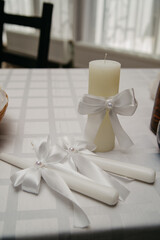 Candles for the wedding bonfire lighting ceremony on the wedding day are lit on a banquet table covered with a white tablecloth