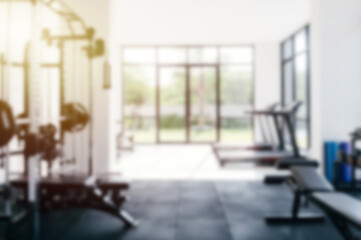 Blurred modern gym with weight machines and treadmills